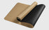 Cork and black yoga mat with textured surface, dual-sided, rolled on white background