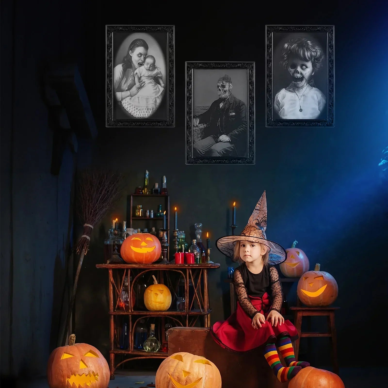 Girl in a red dress with sheer black sleeves, rainbow striped tights, and a printed witch hat sitting among carved pumpkins in a Halloween-themed room.