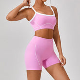 Woman wearing fitted pink athletic crop top and high-waisted shorts with white trim