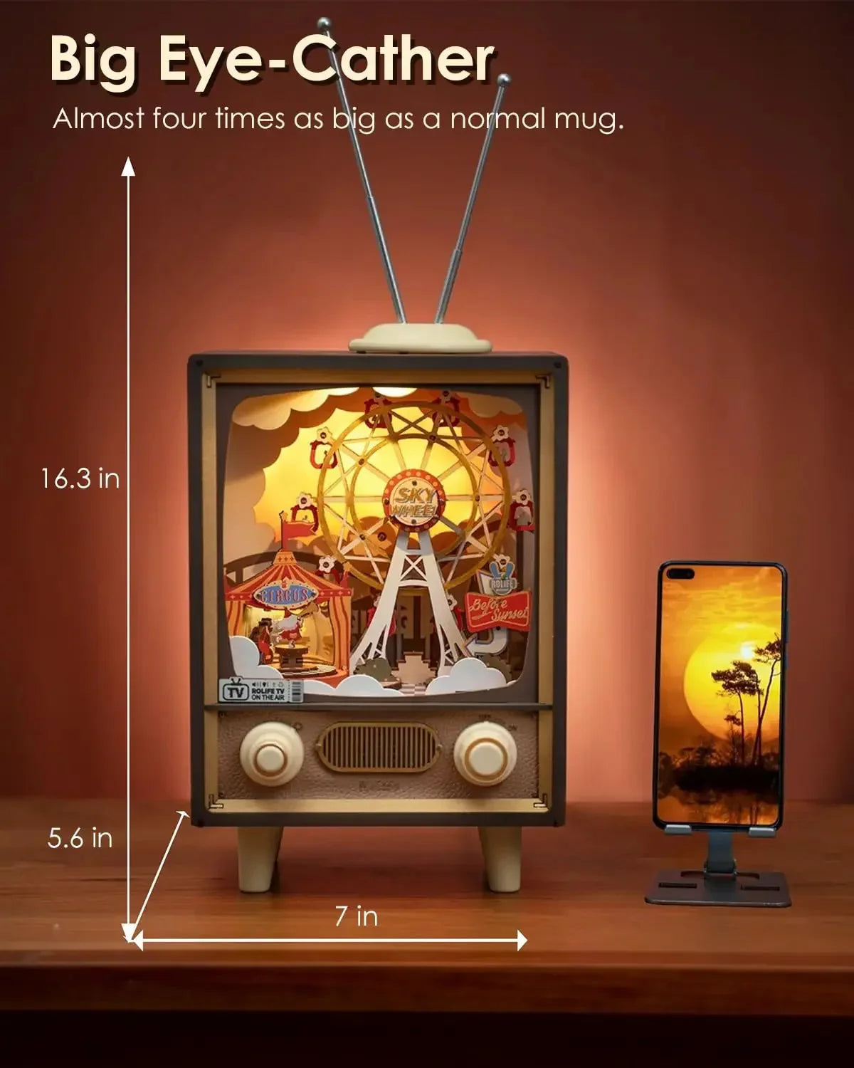 Retro TV-shaped decor piece with ferris wheel design, brown color, 16.3 x 7 x 5.6 inches, compared to smartphone on wood table.