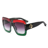 Square oversized sunglasses with red and green gradient frame, black arms, and gold accent.