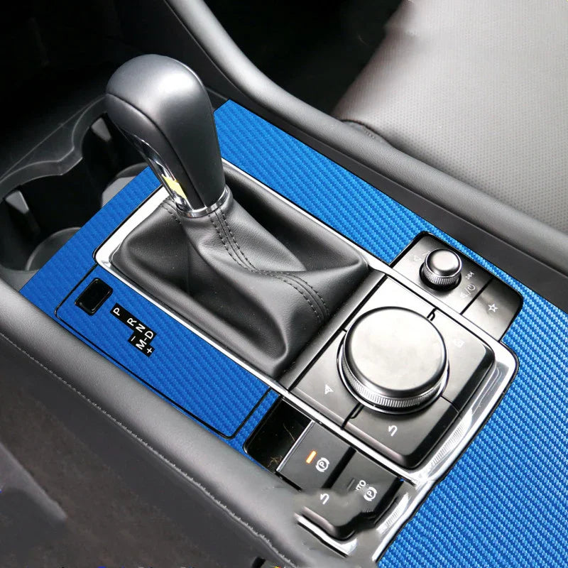 Car center console with blue carbon fiber style trim and black leather gear shift