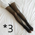 Black sheer tights with a snug fit, worn with a white shirt, displayed on a bed.