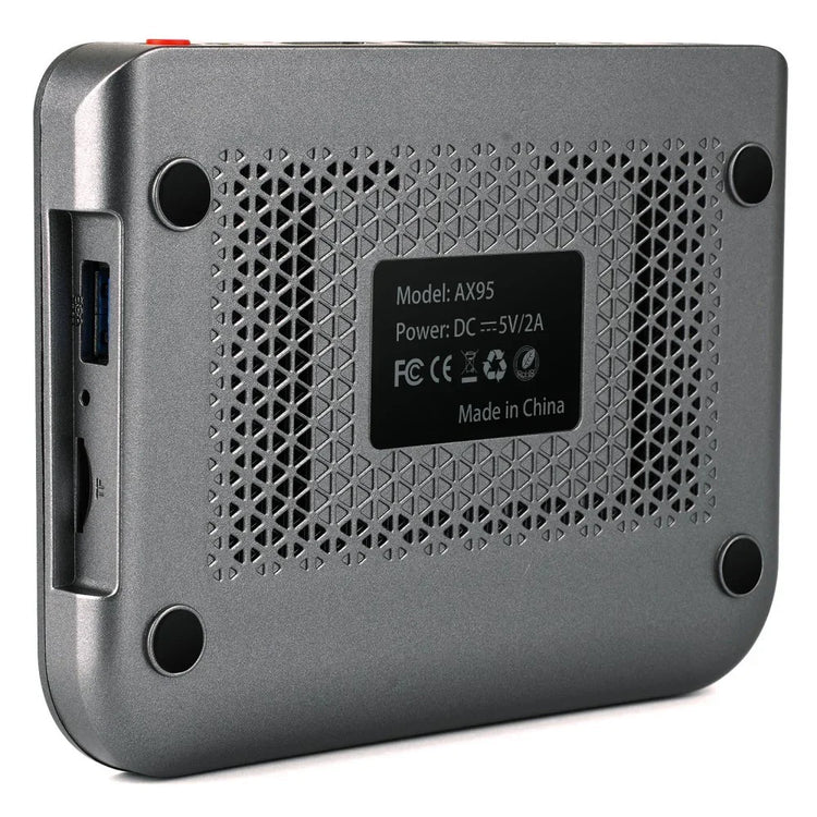Close-up of metallic tech device with ventilation holes, ports, and textured finish