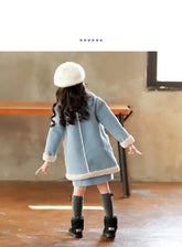 Girl wearing a light blue fleece coat with white trim, gray knee socks, and black boots