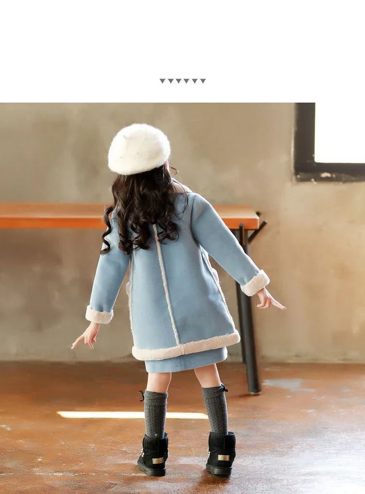 Girl wearing a light blue fleece coat with white trim, gray knee socks, and black boots