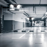 Modern underground parking lot with bright LED ceiling lights and polished concrete floor