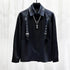 Black long sleeve shirt with metal buckle straps, silver chains, and satin finish, relaxed fit.
