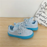 Light blue low-top sneakers with blue soles, suede material, relaxed fit, streetwear style
