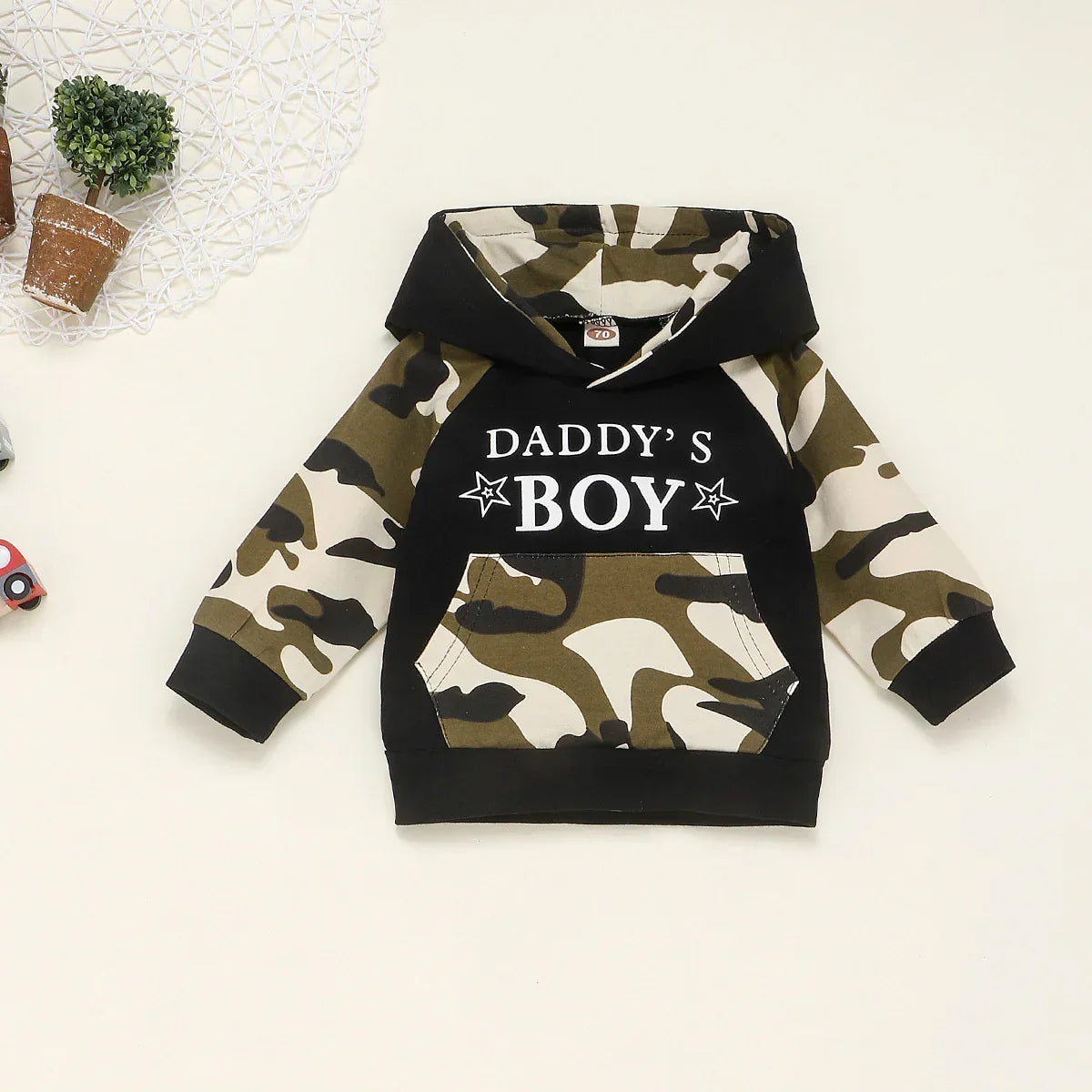 Kids' camouflage hoodie with black front, white text, long sleeves, and front pocket