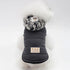 Small dog wearing a padded black jacket with a gray camo hood, quilted design, snug fit.