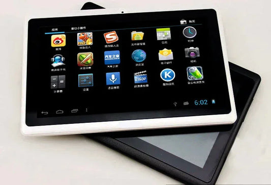 Two touchscreen tablets, one white and one black, displaying app icons on a flat surface.