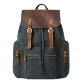Dark canvas backpack with brown leather flap and straps, front zip pockets, vintage style