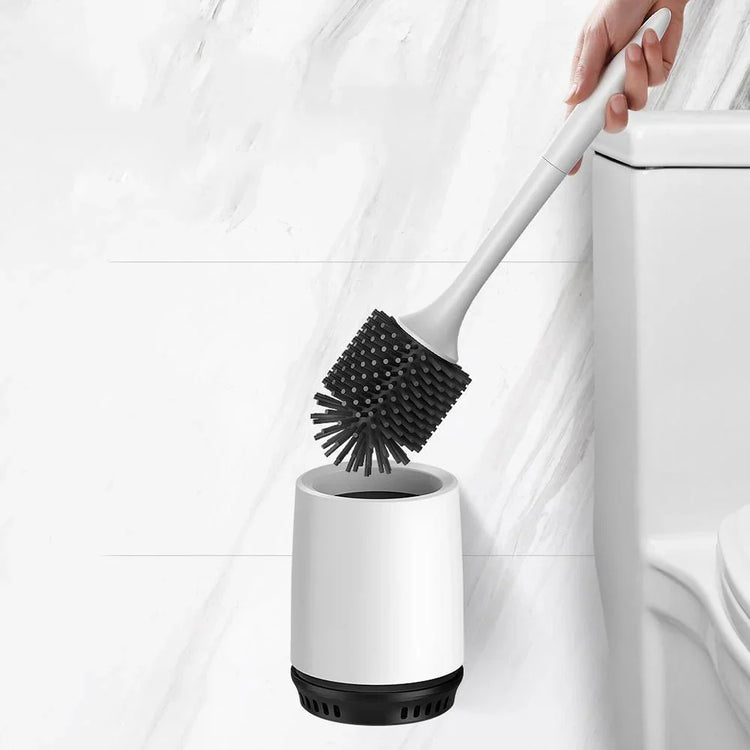 Modern silicone toilet brush with black bristles and white holder next to toilet