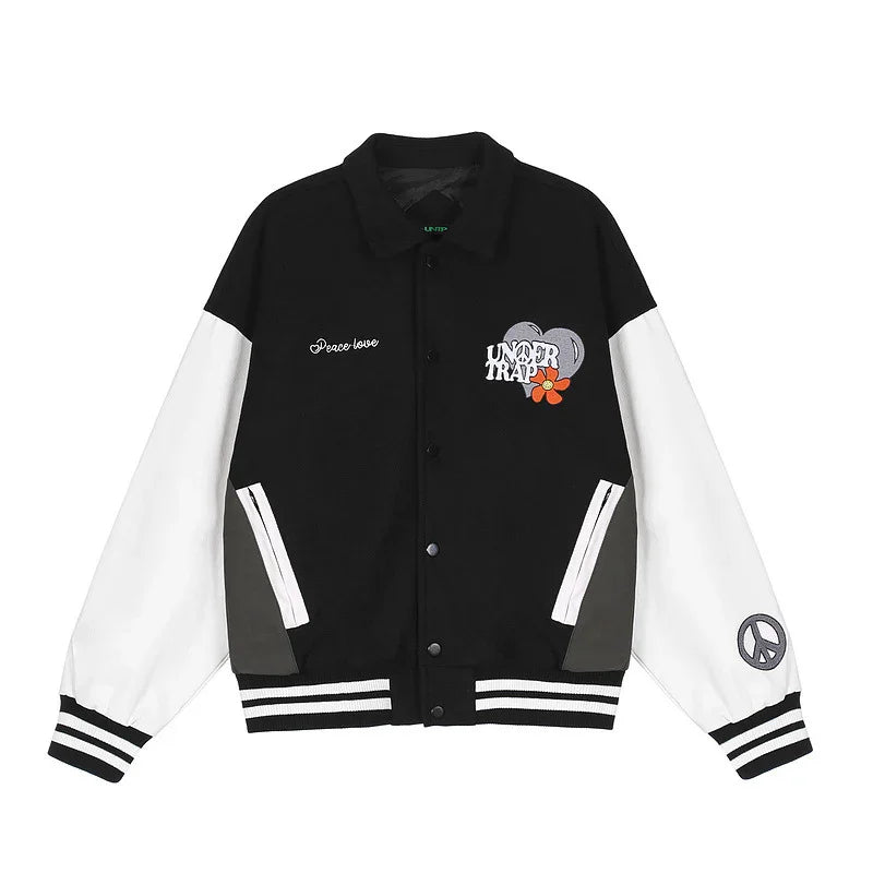Black and white varsity jacket with embroidered graphics, striped cuffs, relaxed fit.