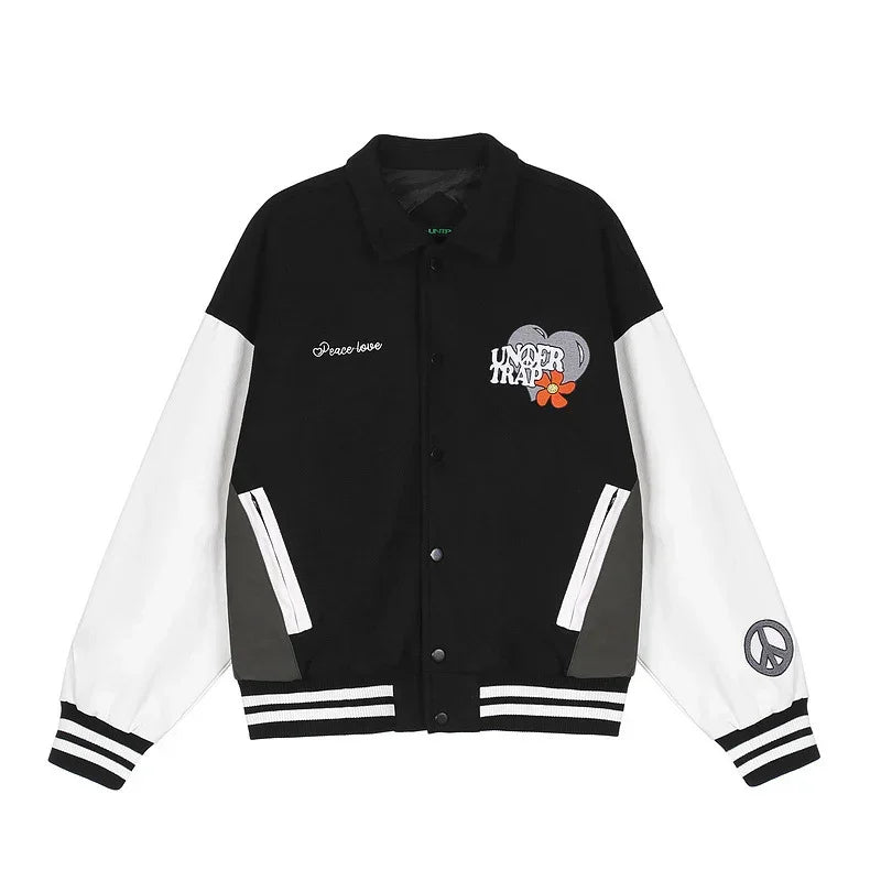 Black and white varsity jacket with embroidered graphics, striped cuffs, relaxed fit.