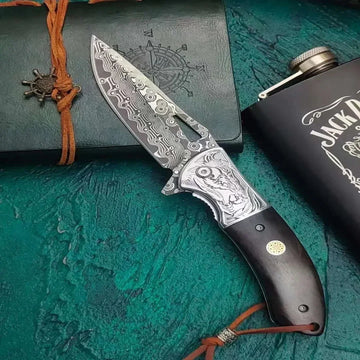 Ornate Damascus steel folding knife with engraved patterns and dark wood handle on textured background.