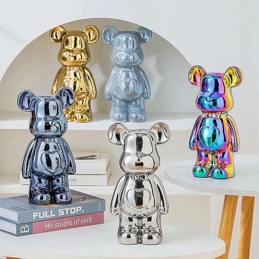 Colorful metallic bear figurines in gold, silver, chrome blue, and iridescent finish on white shelves