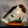 Fantasy resin sculpture with dragons, castle, and glowing landscape on wooden base