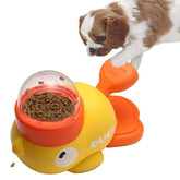 Puppy using yellow and orange interactive duck-shaped pet food dispenser toy
