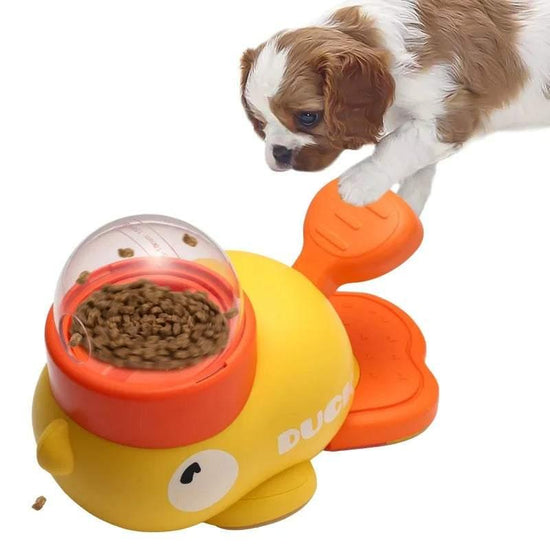 Puppy using yellow and orange interactive duck-shaped pet food dispenser toy