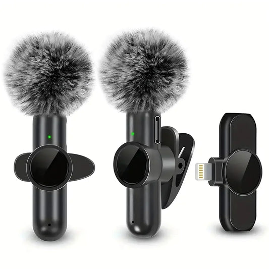 Wireless clip-on microphones with gray furry windshields and black charging adapter
