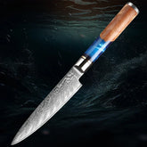 Damascus steel chef knife with textured blade and resin wood handle on dark background