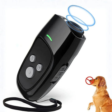 Black handheld ultrasonic dog training device with wrist strap, shown in use with a dog.