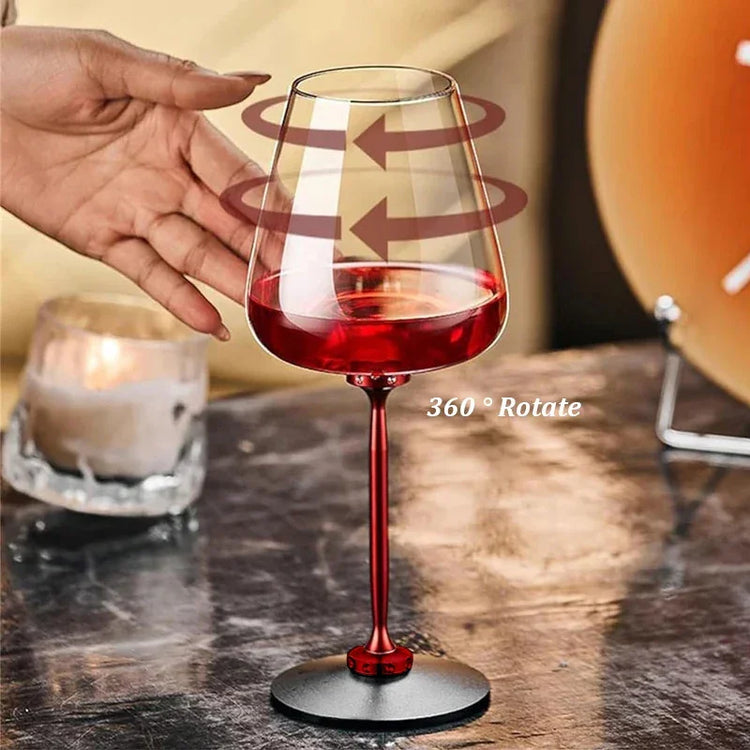 Rotating red metal stem wine glass with sleek modern design on a dark table