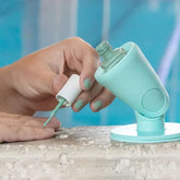 Hand painting nails with mint green nail polish, using a silicone nail polish holder