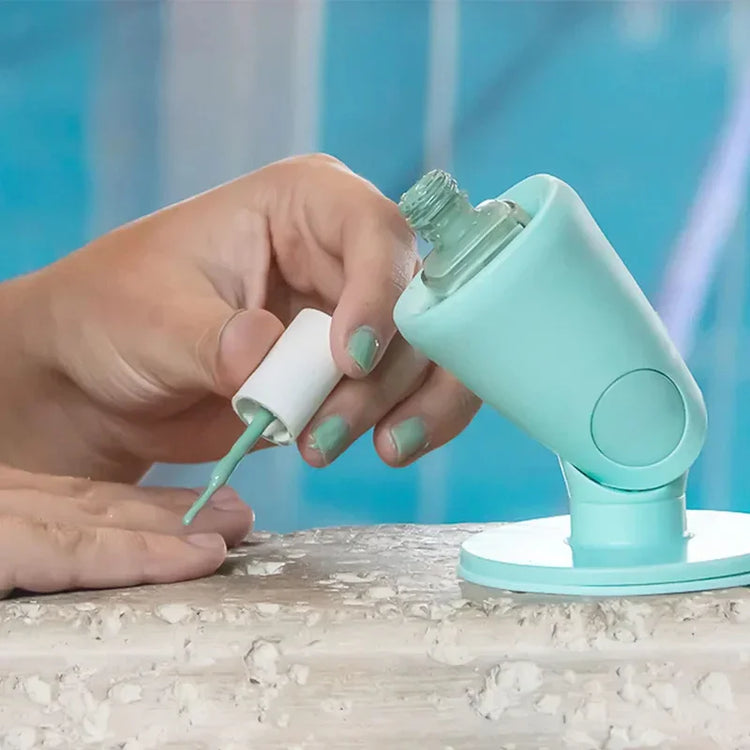 Hand painting nails with mint green nail polish, using a silicone nail polish holder