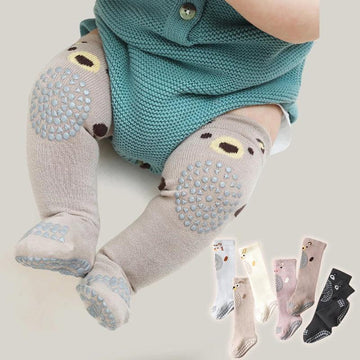 Baby wearing beige knee-high non-slip socks with bear faces and textured grip, soft knit material.