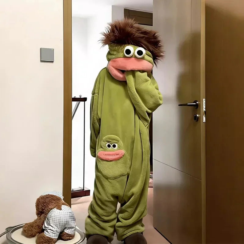 Person wearing oversized green plush onesie with cartoon face, relaxed fit, and fuzzy hood.