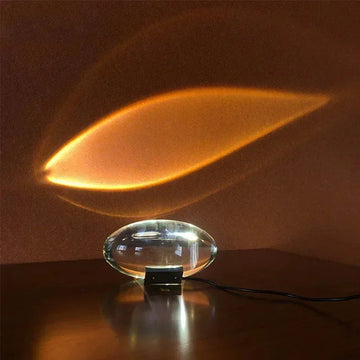 Futuristic glass table lamp projecting warm amber light on wall, modern home decor