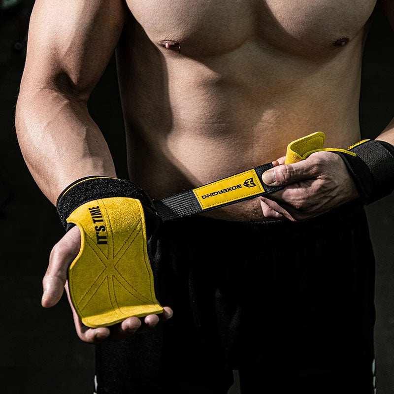 Man wearing yellow and black padded lifting gloves with adjustable wrist straps, athletic fit