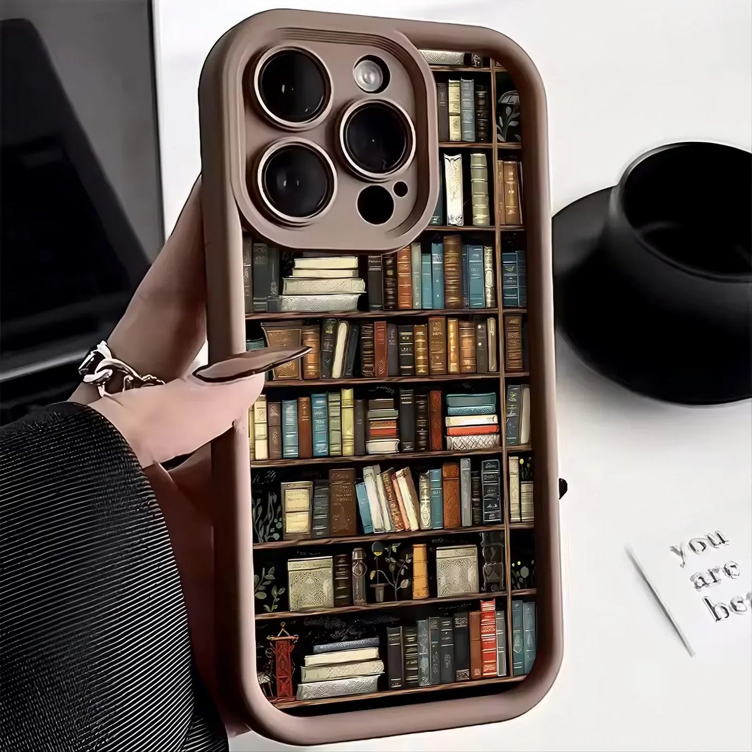 Brown phone case with colorful bookshelf print, glossy finish, slim modern fit