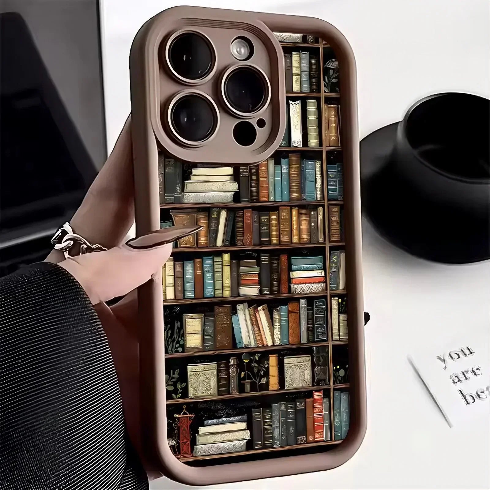 Brown phone case with colorful bookshelf print, glossy finish, slim modern fit