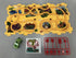 Yellow dinosaur-themed play mat with road track, green toy car, stickers, and red traffic sign pieces.