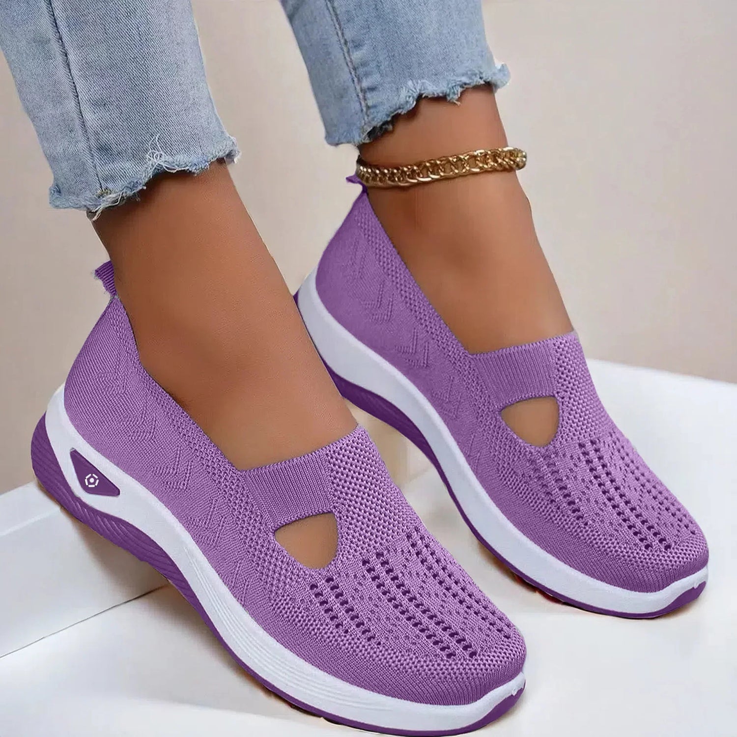 Lavender slip-on knit sneakers with breathable mesh, white soles, and casual fit.
