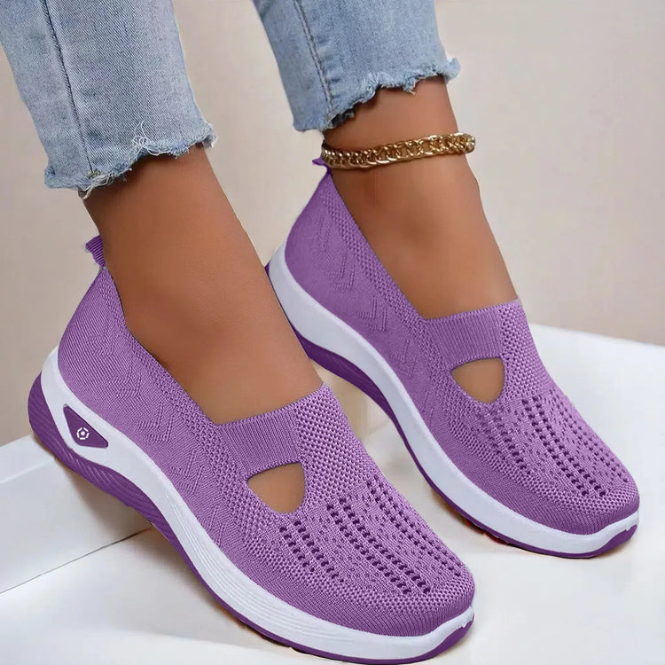 Lavender slip-on knit sneakers with breathable mesh, white soles, and casual fit.