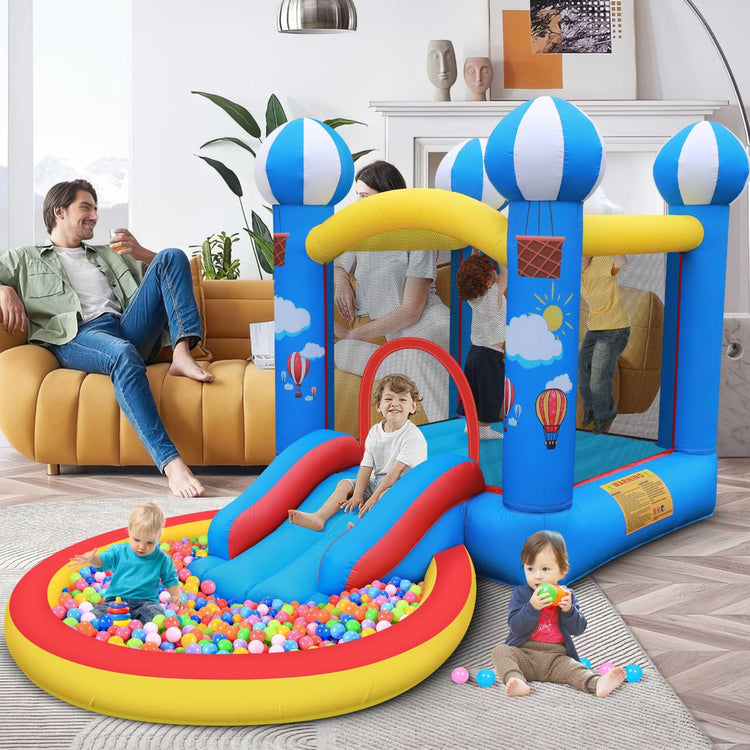 Kids in bright casual outfits playing on colorful inflatable bounce house and ball pit indoors.