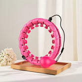 Pink adjustable plastic fitness hoop with massage nodes, weighted ball, modern design