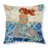 Decorative pillow with a colorful mermaid illustration, blue patterned tail, and ocean background.
