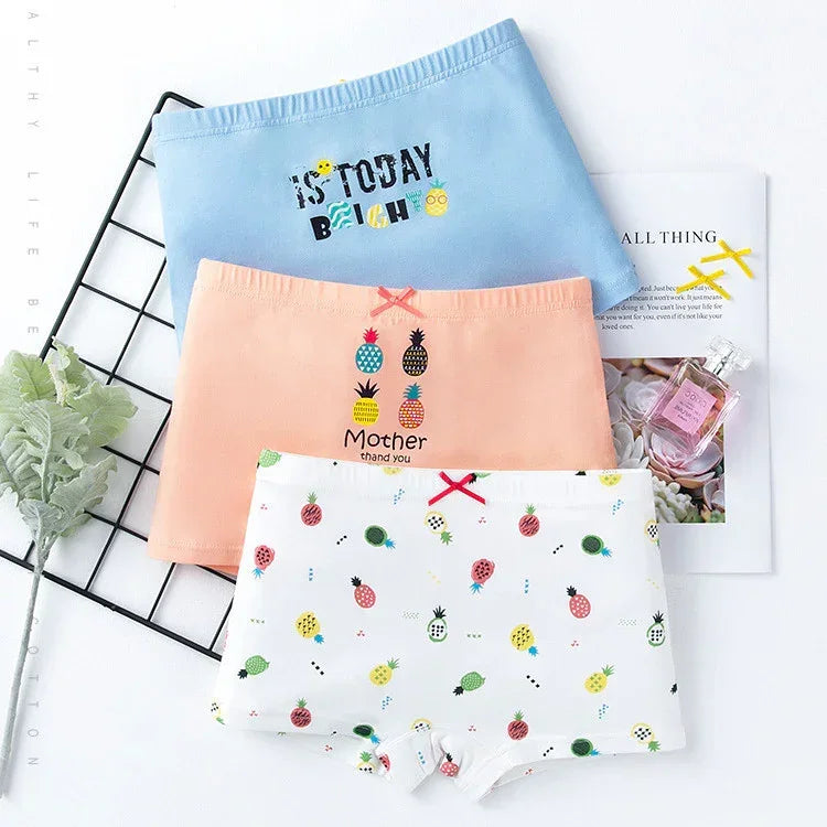 Colorful women's cotton underwear set with fruit prints and cute bow details, laid flat.