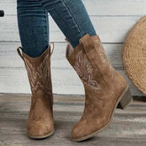 Brown suede cowboy boots with embroidery, mid-calf, paired with skinny blue jeans.
