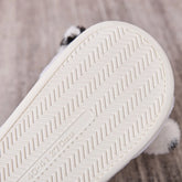 Close-up of white rubber sole with herringbone tread pattern on footwear