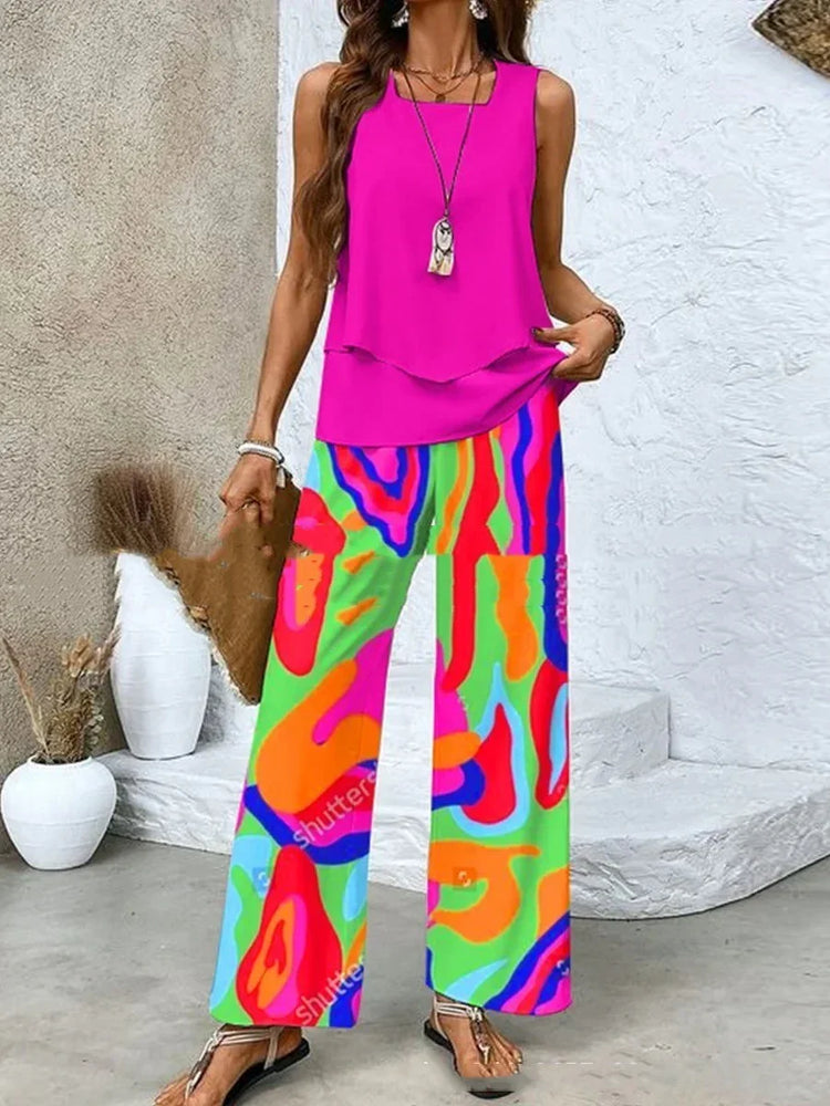 Woman wearing a sleeveless hot pink top with loose, wide-leg, multicolor abstract print pants.
