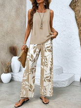 Woman wearing beige sleeveless top and wide-leg, leaf-print palazzo pants in lightweight fabric