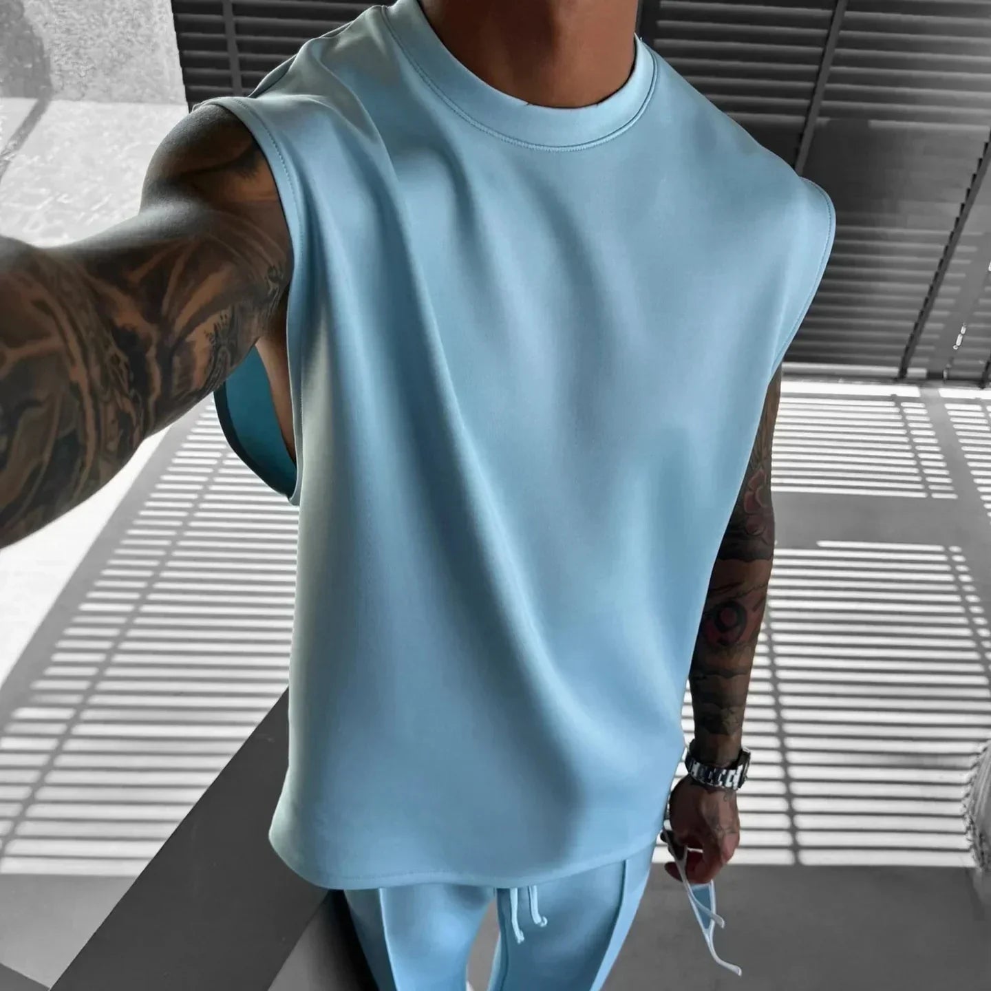 Man wearing light blue sleeveless top and matching joggers, relaxed fit, soft material