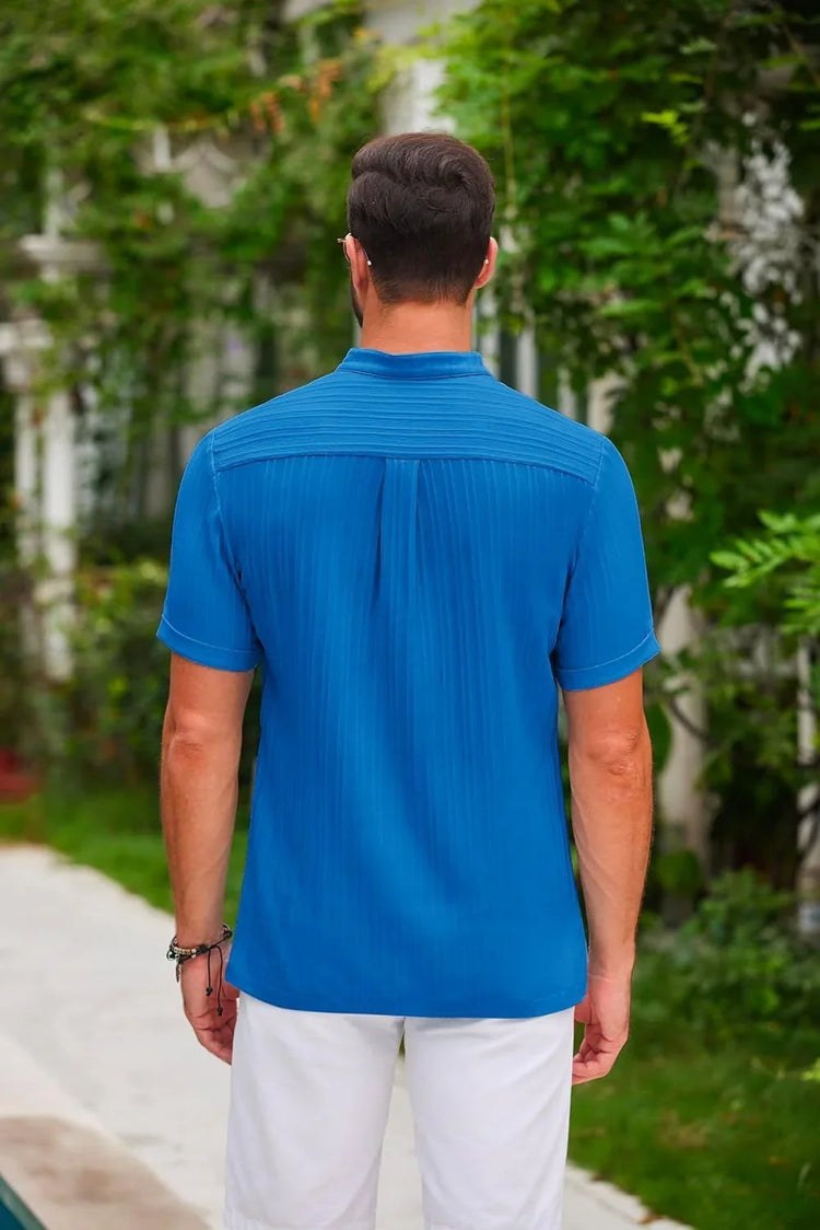 Man wearing short sleeve, slim fit blue textured shirt and white shorts outdoors